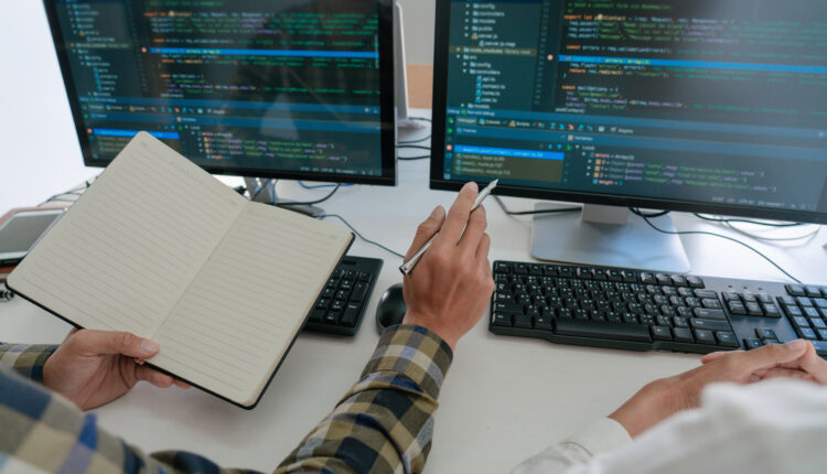 Decorative image of programmer examining code on screen